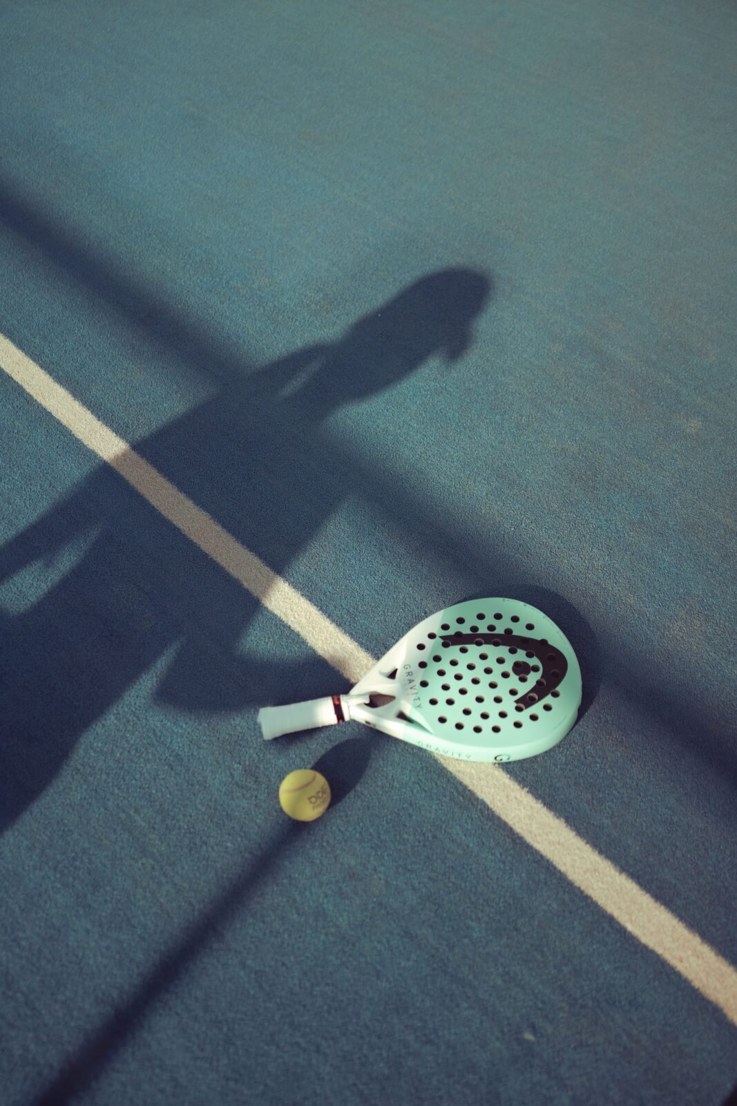 Padel-Schläger von Head lehnt an der Glaswand eines Courts